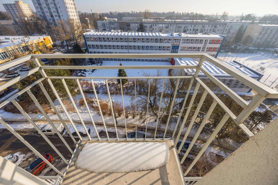 Balcony view overlooking surrounding buildings and outdoor space.