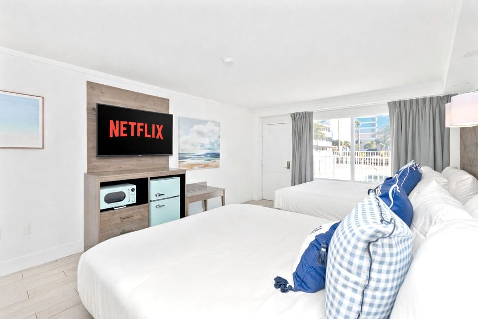 Bright, modern room with two cozy queen beds, a sleek flat-screen TV where guests can enjoy Netflix. Equipped with a mini fridge, microwave, and full curtains for privacy—designed for comfort and a truly restful stay.