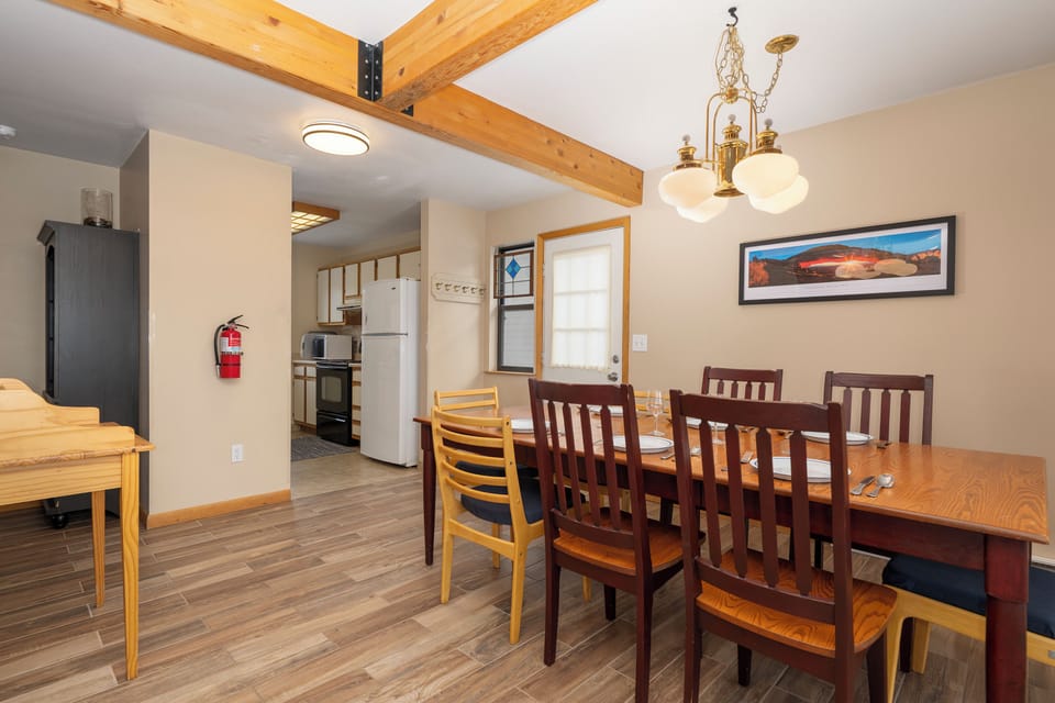 Gather around your spacious dining table with exposed beams overhead, creating memorable meals in this warm, well-appointed space.