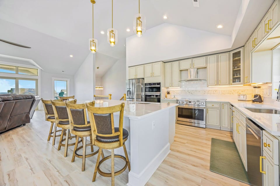 Your gourmet kitchen features elegant cabinetry, stainless appliances, and a spacious island with seating—perfect for preparing meals and gathering together over conversation.