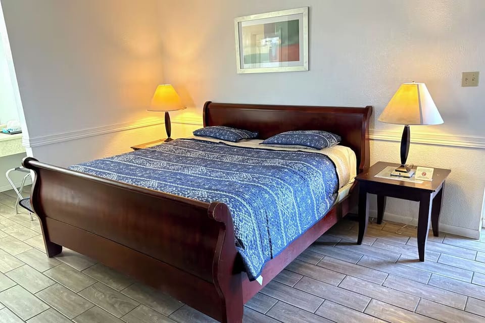 Unwind into a freshly made bed under warm bedside lighting.