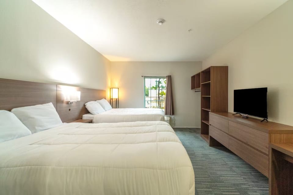 Wake up refreshed in airy double-queen room with sunny window.