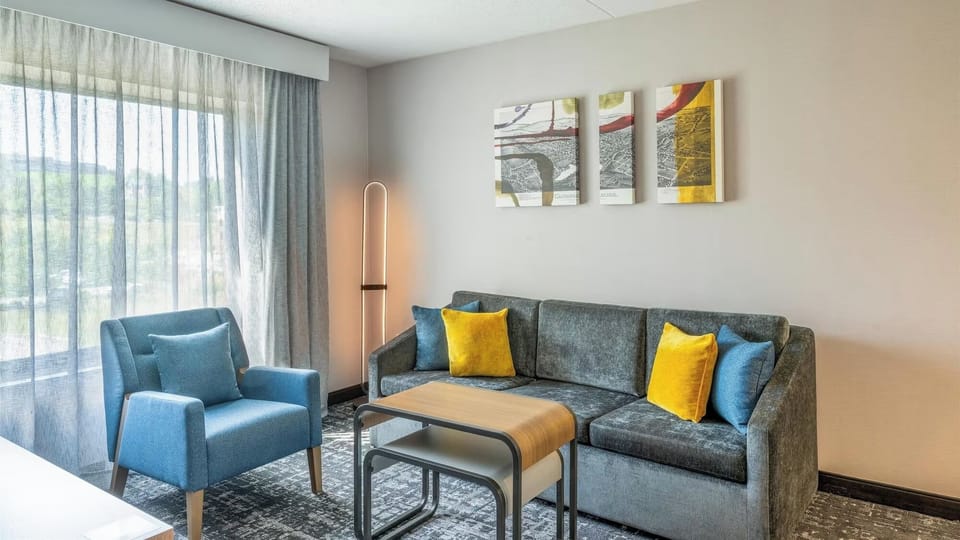 Lounge comfortably in a bright sitting area with soft curtains.