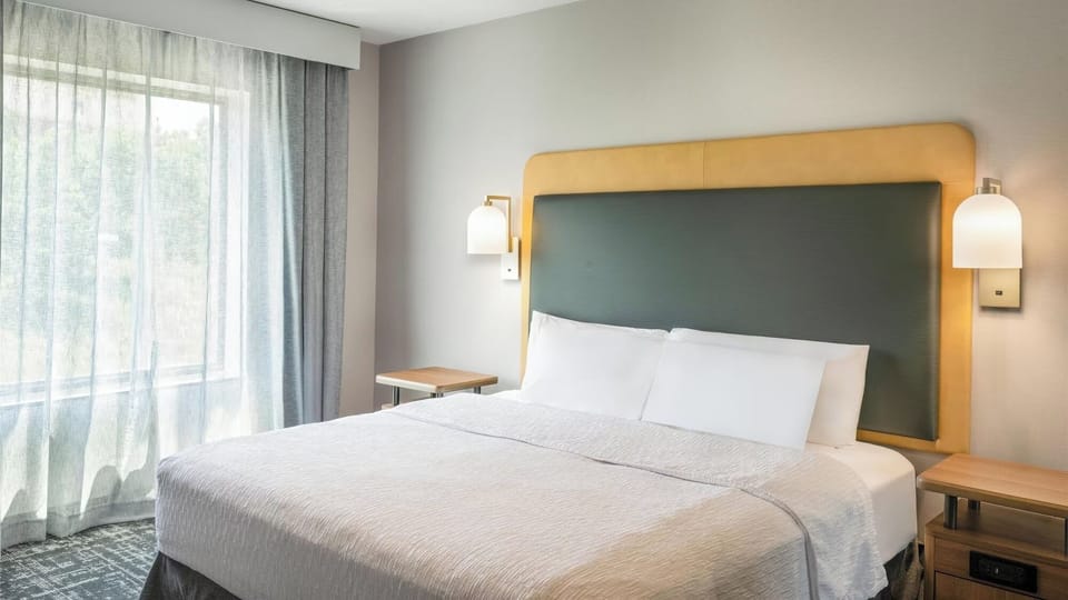 Unwind in crisp linens beside soft, sunlit windows.