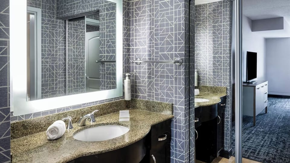 Refresh at a sleek vanity with bright, flattering mirror.