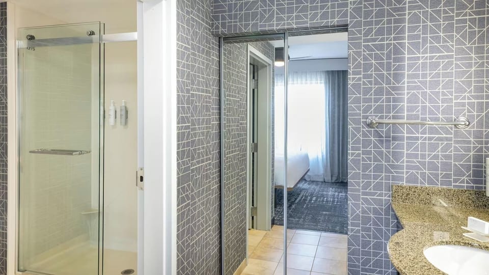 Rinse off in a clean, glass shower with roomy space.