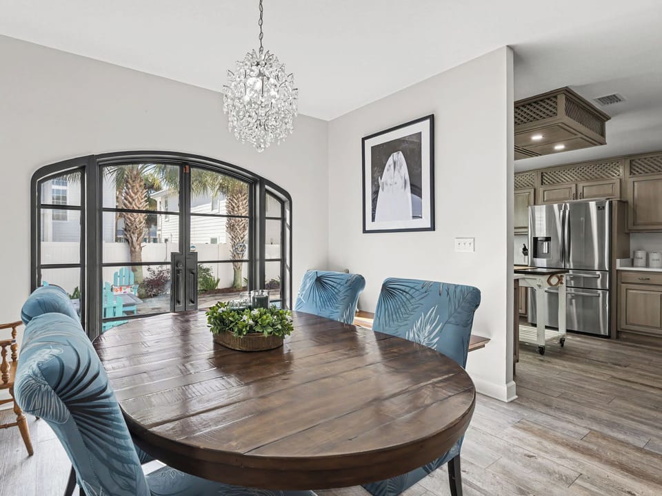 You'll love gathering around this elegant dining table beneath the sparkling chandelier, with natural light streaming through beautiful French doors.