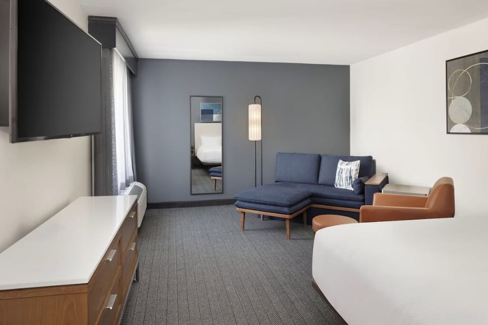 Settle in with spacious seating, sleek TV, and airy design.