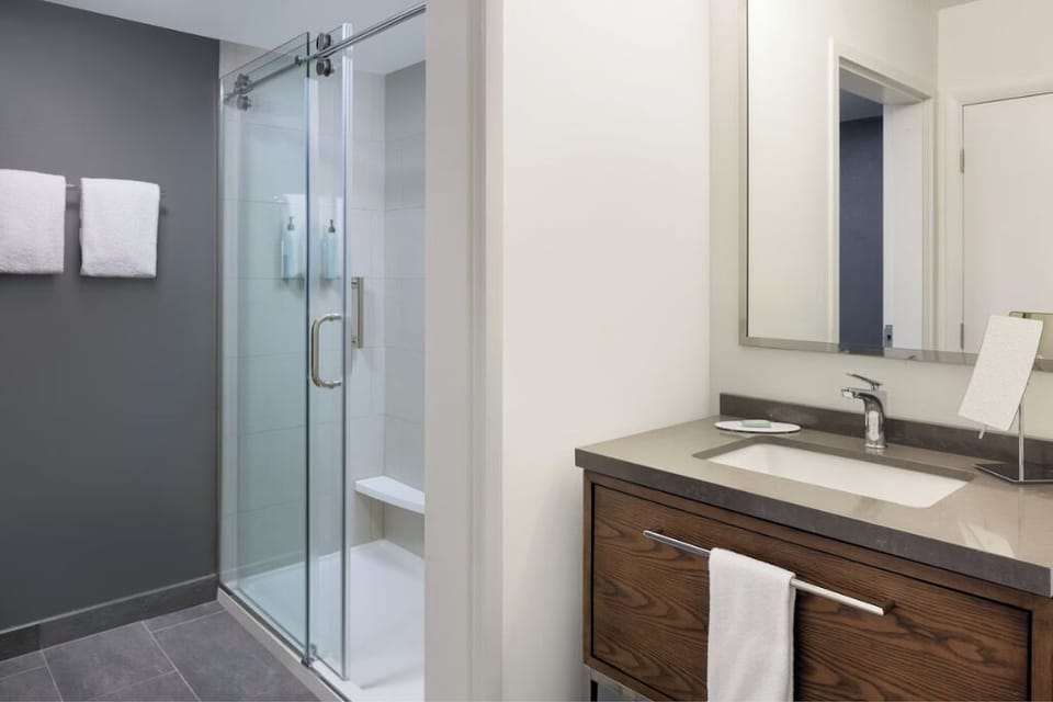 Refresh in a spotless bath with glass shower and bright vanity.