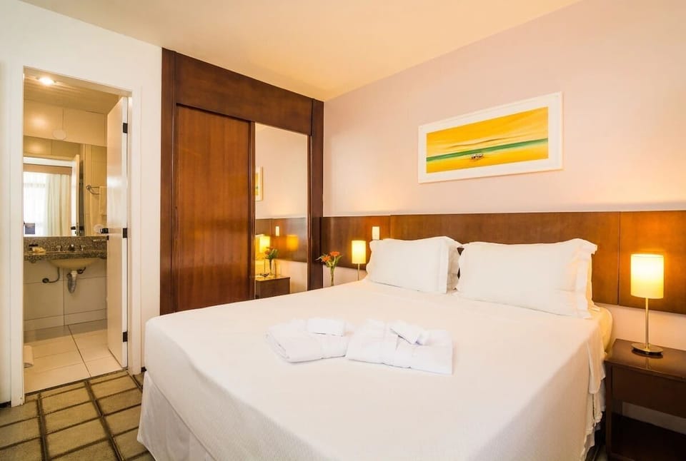 Relax in a cozy suite with soft lighting and linens.