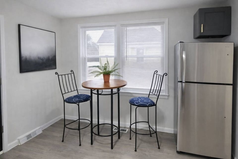 This modern, fully equipped kitchen features sleek gray cabinetry and stainless steel appliances, complete with a cozy breakfast bistro set perfect for enjoying your morning coffee or tea.