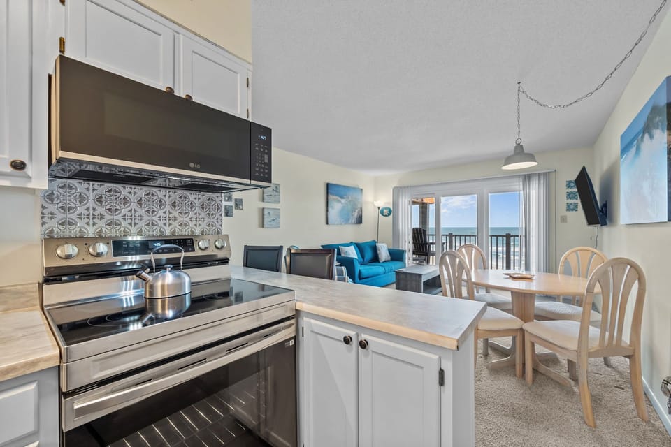 Open-concept kitchen and dining area with ocean views; perfect for cooking, gathering, and enjoying the sea breeze together