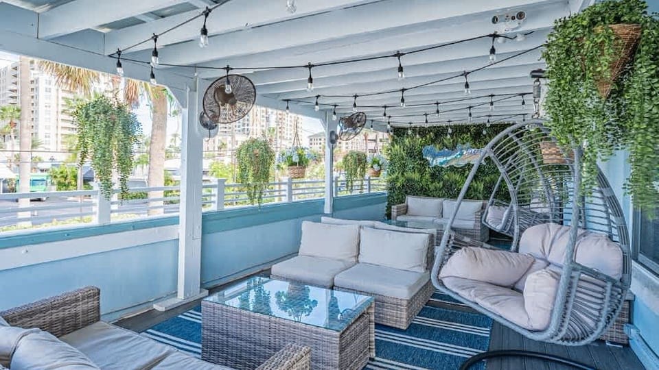 Lounge under string lights on a breezy, shaded deck.
