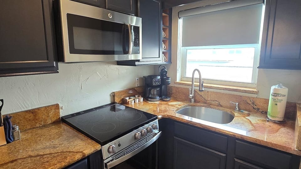Start mornings with coffee beside generous granite counters.