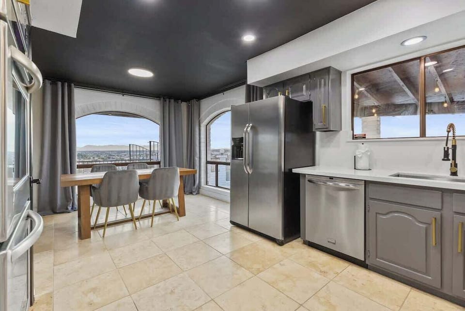 A light-filled kitchen with arched windows and city views—designed for easy mornings, casual meals, and seamless flow to the pool and outdoors.
