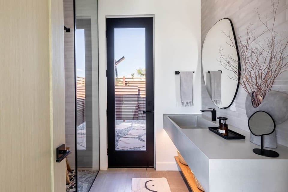 2nd Bathroom custom concrete banity sink, door  leads to outdoor leads tonoutdoor shower and pool