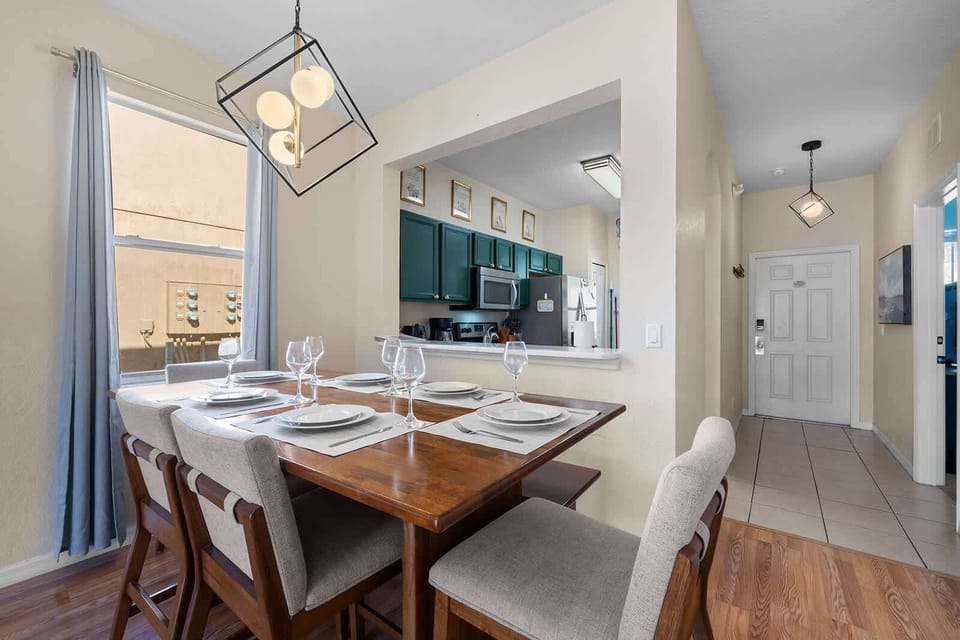 Dining area w/ a wood table & warm light — inviting space to gather & share a meal.
