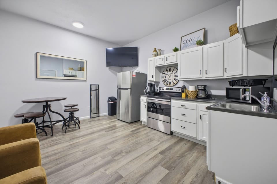 Bright kitchenette with stainless appliances, TV & bistro dining
