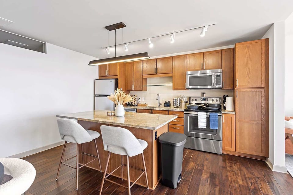 Open concept kitchen and dining area with bar seating, sleek finishes, and plenty of room to gather. The layout flows seamlessly into the living space, ideal for shared meals and relaxed evenings indoors.
