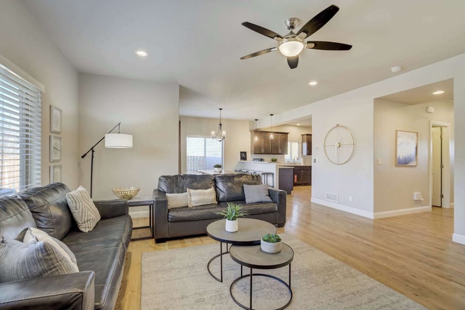 This open-concept main level creates a bright environment for relaxation. Large windows and overhead fans keep the space airy, while the layout connects the living room directly to the dining area for seamless flow.
