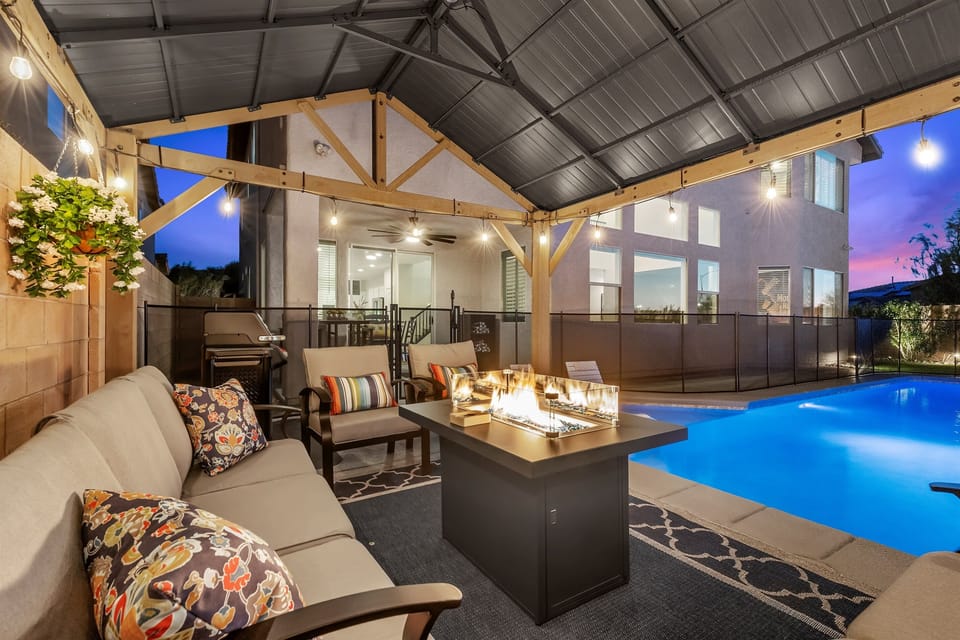 Cozy ramada that elevates outdoor living with a firepit and string lighting.