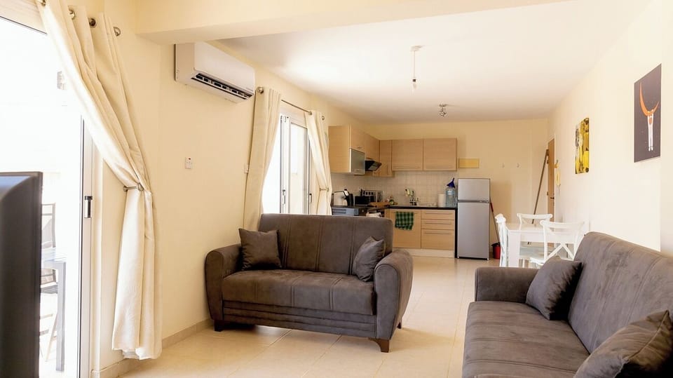 Bright lounge with TV, a 2 seater and 3 seater settees, Air Conditioning, patio door leading to the large spacious terrace.