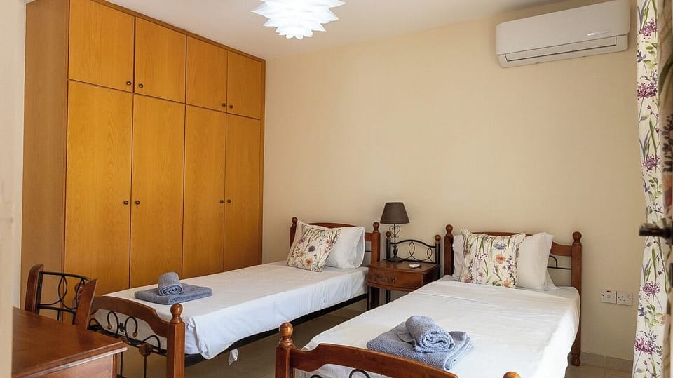 Twin bedroom with air condioning, built in wardrobes, patio doors leading to the  2nd terrace with table & chairs.