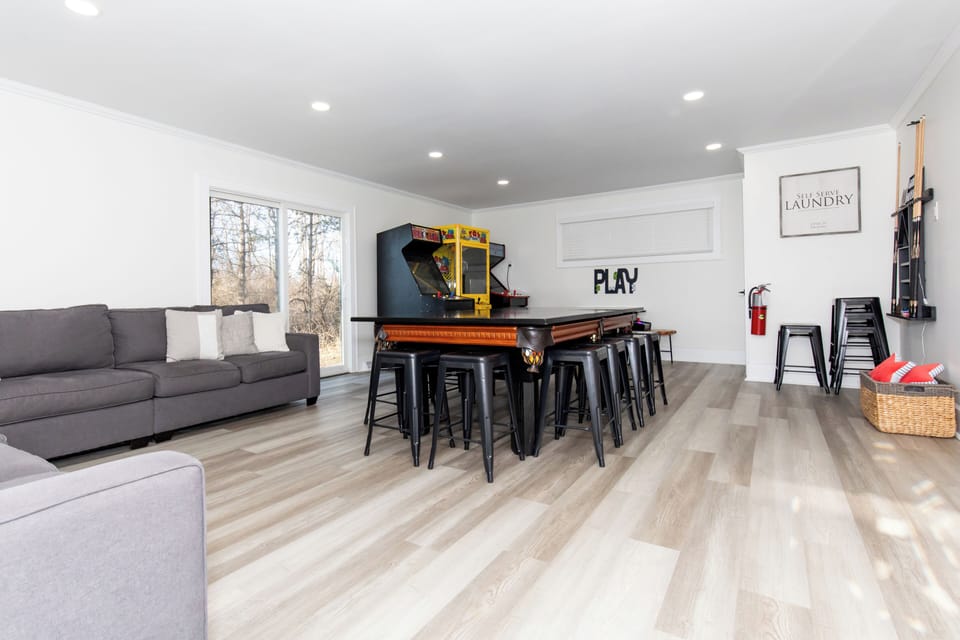 Your entertainment paradise awaits with a vintage arcade game, pool table, and cozy seating for endless group fun.