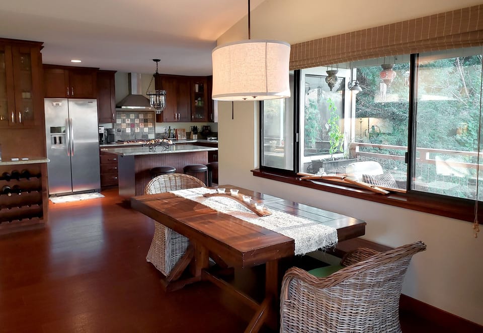 A spacious kitchen flows into a welcoming dining area where you'll craft meals and share stories around the handcrafted wooden table.