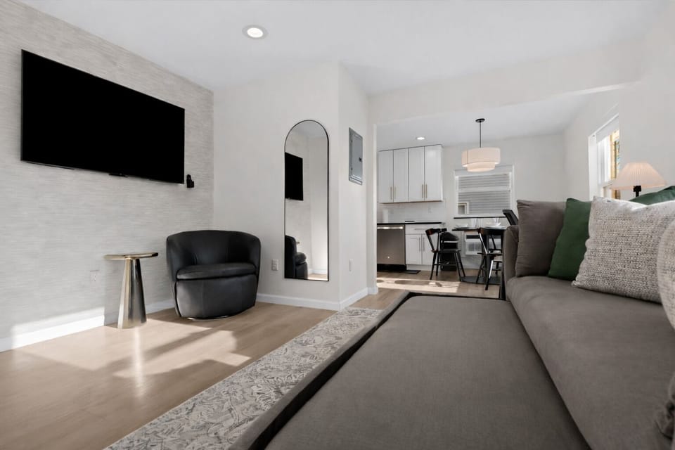 Open, modern living space with a pull-out sofa, smart TV, and stylish seating—perfect for relaxing, entertaining, or hosting additional guests.