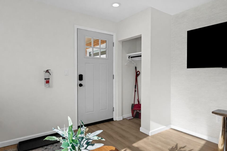 Bright, modern entryway with smart lock access, warm flooring, and convenient storage—offering a clean, welcoming first impression as you step inside.