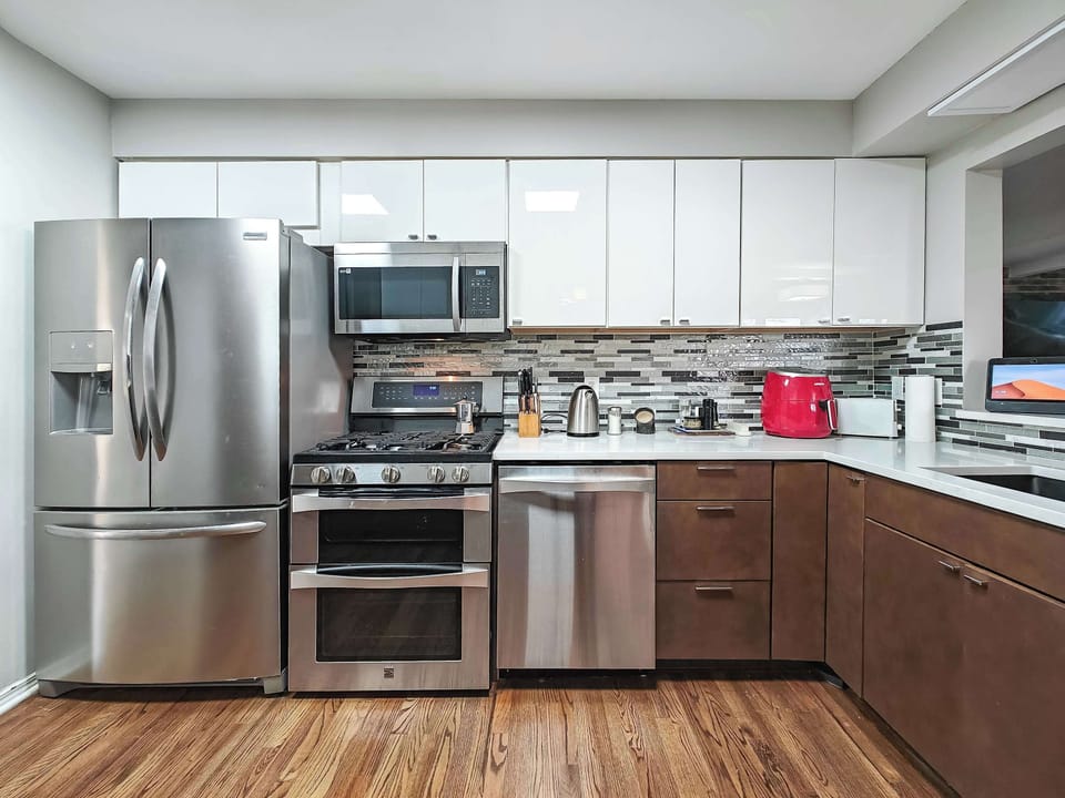 Kitchen has stainless appliances featuring refrigerator with icemaker, microwave, double oven, dishwasher and trash compactor.