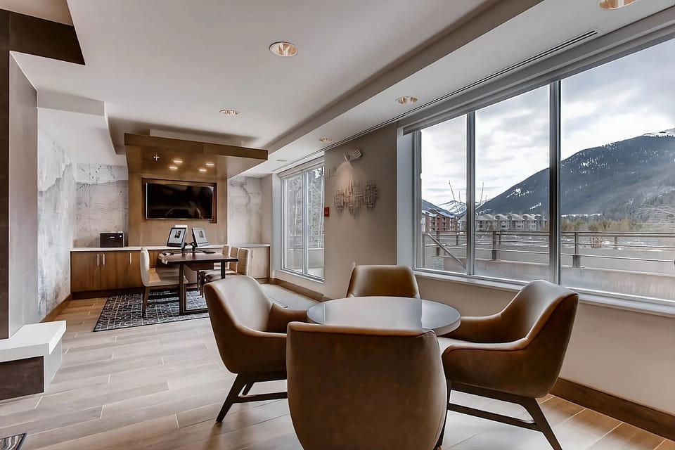 Relax together in plush seating beside expansive mountain windows.