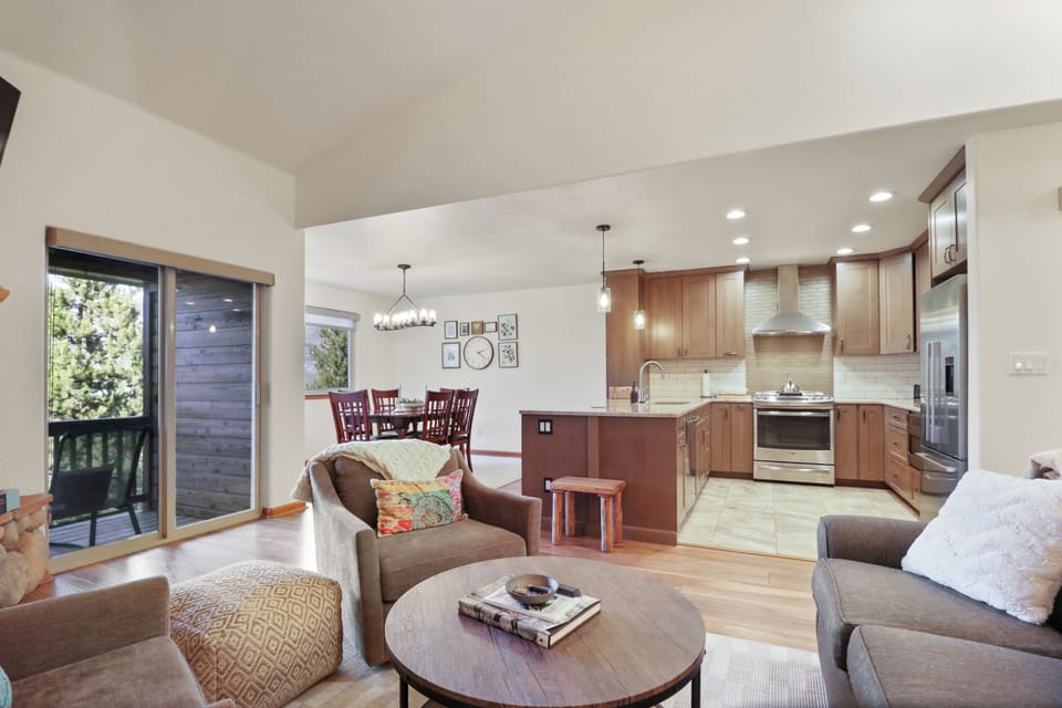 Your modern open-plan living space flows seamlessly from comfortable seating to fully equipped kitchen, perfect for unwinding after mountain adventures.