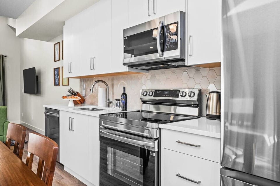 This inviting full kitchen features sleek stainless steel appliances, blending style and functionality perfect for preparing home-cooked meals.