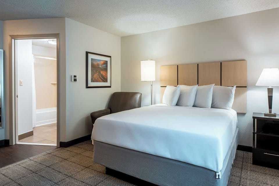 Unwind in a bright, crisp bedroom with soft lighting.