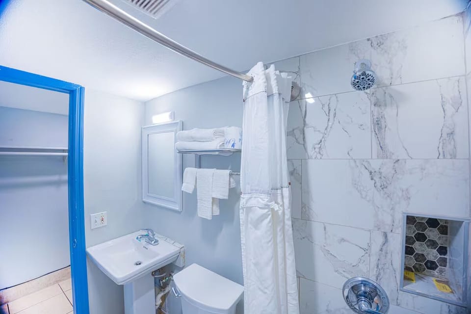 Rinse off under a hot shower in a bright bath.