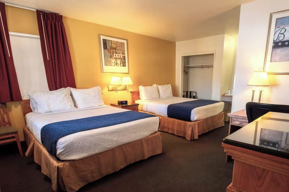 Unwind in a bright double-queen room with cozy lighting.
