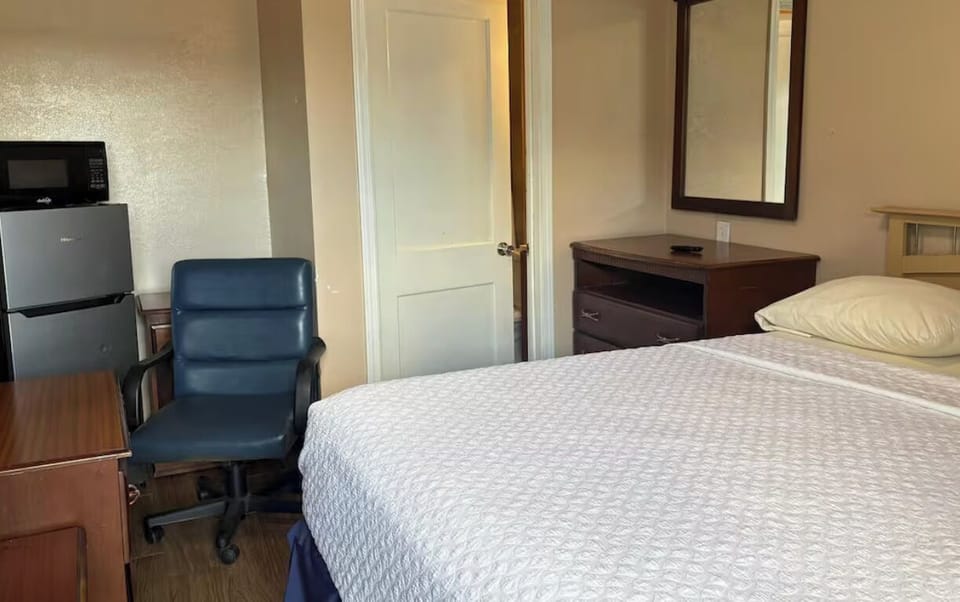 Recharge in a cozy room with workspace and mini fridge.