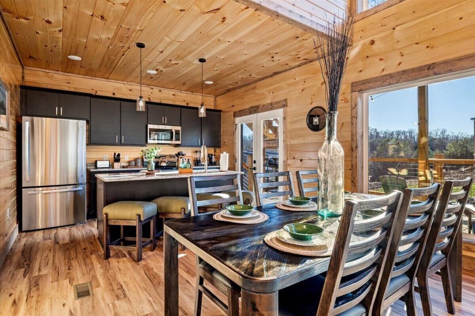 Gather around this rustic dining table where warm wood surrounds you and scenic views stretch beyond your windows, creating perfect moments.