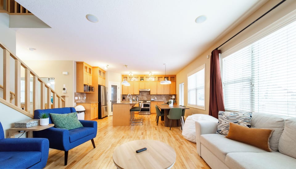 Spacious living area with cozy sectional, natural light, and modern comfort