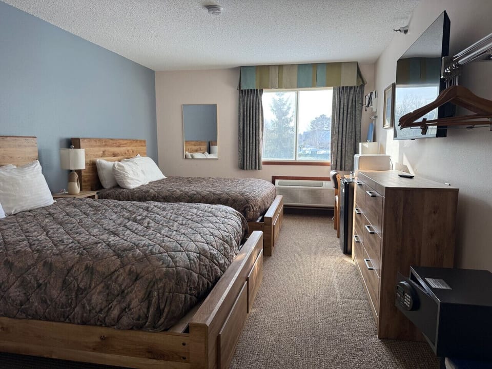 Spacious double queen room offering rustic charm and natural light.