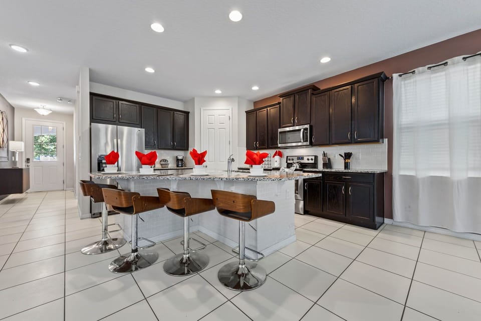 Chef-ready kitchen with stainless appliances, granite counters, espresso cabinetry, and a roomy island for 4-perfect for breakfasts and evening chats.