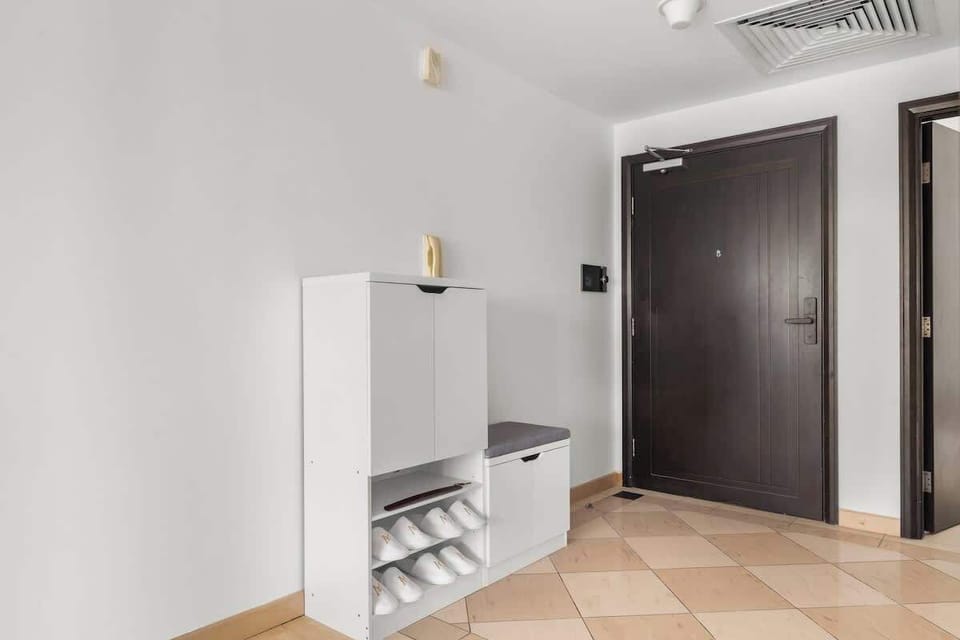  Entryway with a sleek shoe cabinet, bench, and complimentary guest slippers. A practical and welcoming touch that keeps the space tidy while offering comfort right as you arrive.