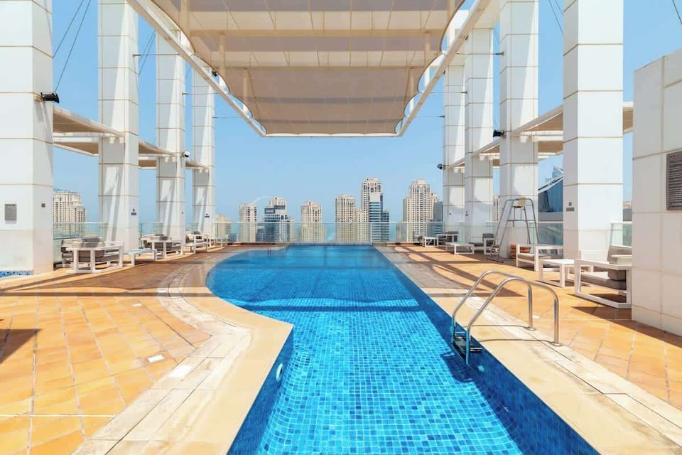 Rooftop infinity pool with panoramic skyline views, modern lounge seating and shaded areas. The perfect spot to swim, relax and enjoy Dubai’s stunning cityscape.