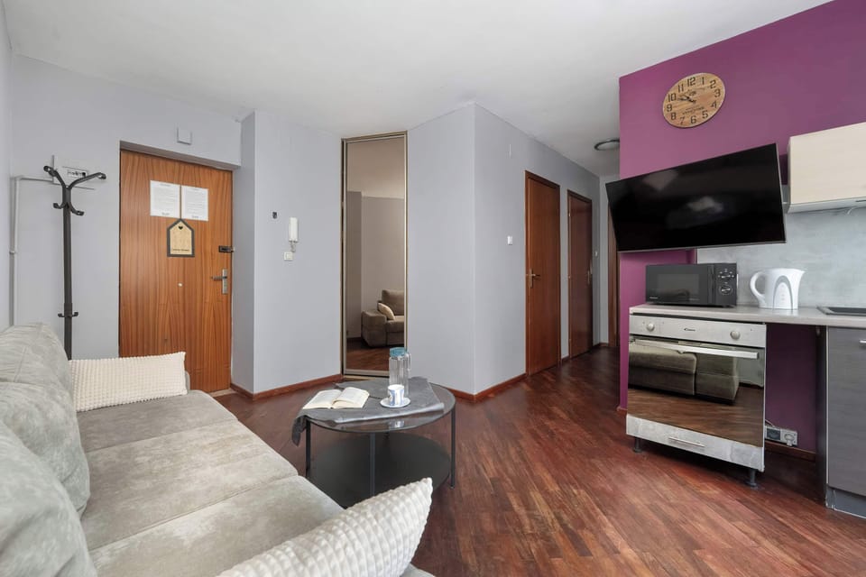 Living room with sofa and wooden flooring.