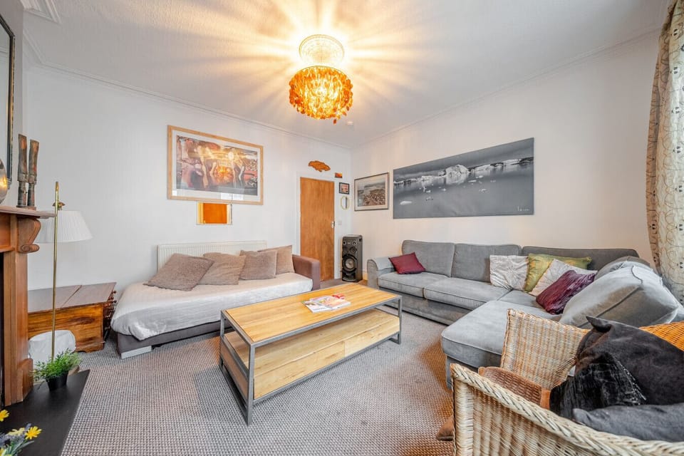 Spacious living room with sofas, coffee table, and ceiling light feature
