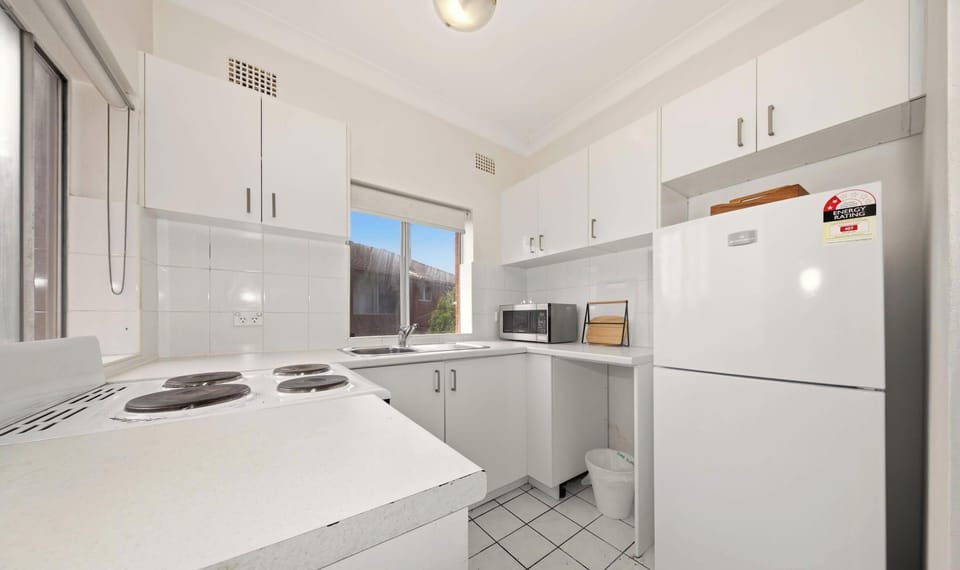 Neat and functional kitchen equipped with essential appliances and ample storage space.