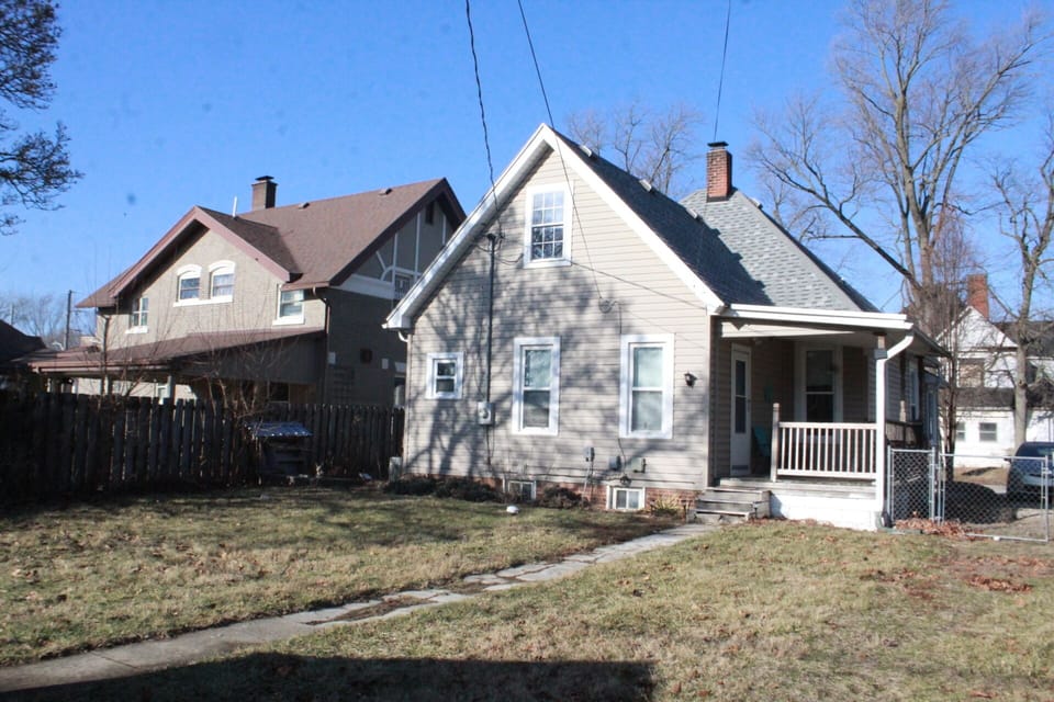 Backyard view including porch and parking area. 