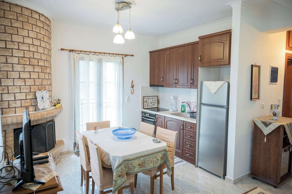 Dining area with fireplace and fully equipped kitchen.